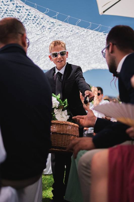 Junge mit Sonnenbrille verteilt Blüten an die Gäste